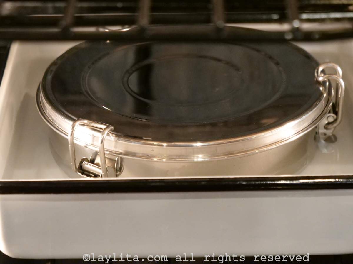 Quesillera or flan mold with a cover in a water bath in the oven