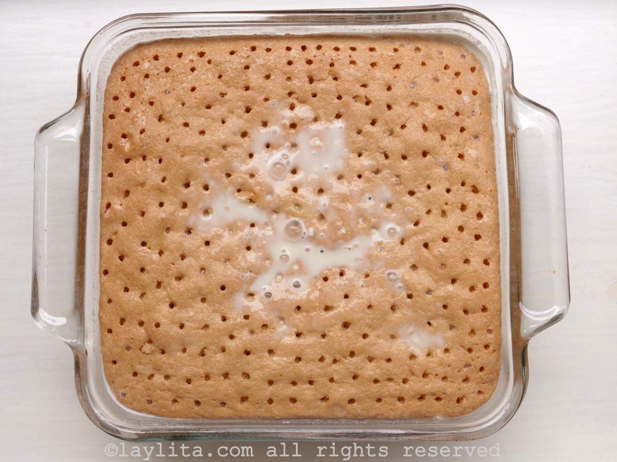 Overhead shot of cake with holes in it and milk mixture showing on top.