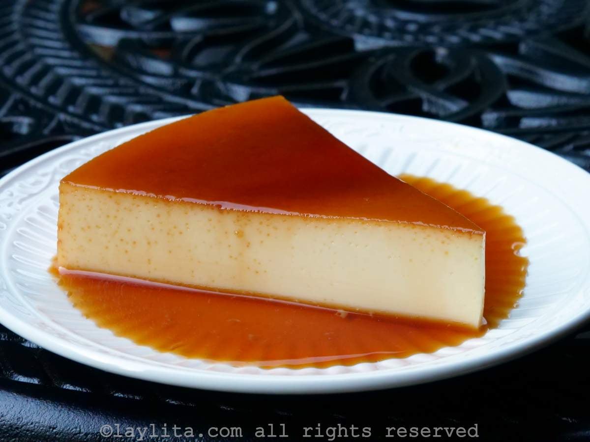 Side view of a slice of flan on a white plate.