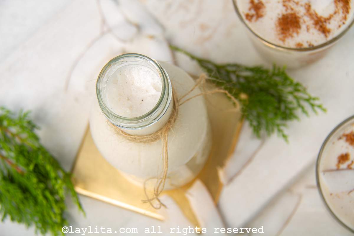 Coquito poured into a large glass bottle.