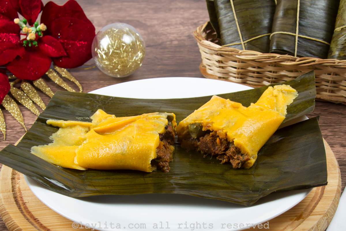 Venezuelan hallaca on a banana leaf split in half to show the inside filling.
