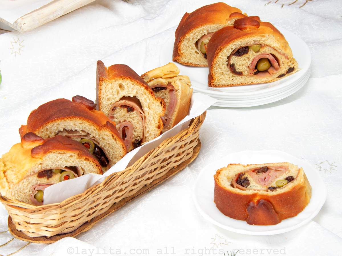 Venezuelan Christmas bread on a plate with more in a basket next to the plate.