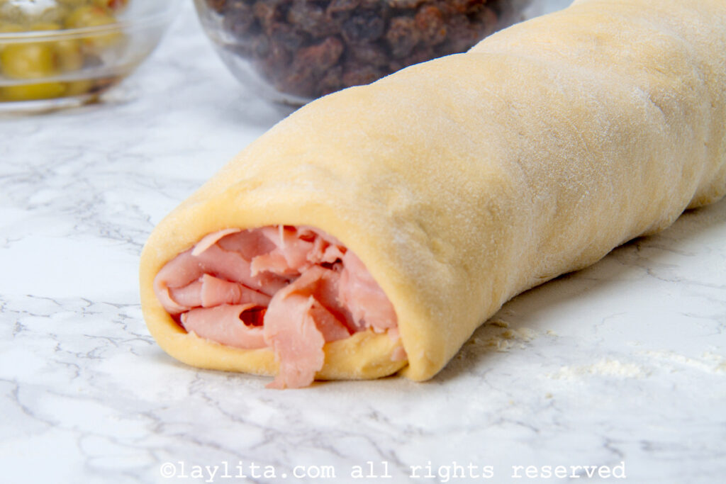 Rolled up unbaked loaf of ham bread