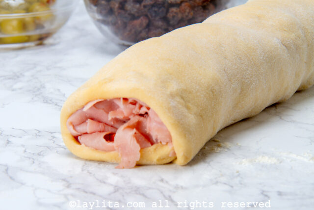 Rolled up unbaked loaf of ham bread