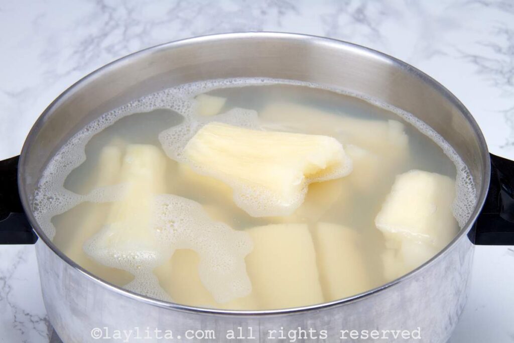 Pieces of yuca boiling in a large stock pot.