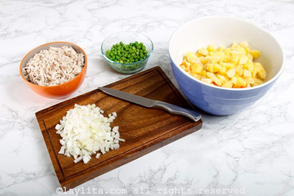 Diced white onion on a wooden cutting board