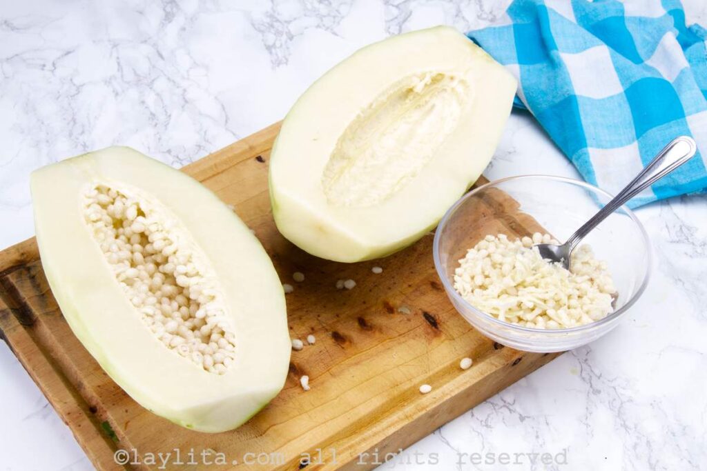 Peeled green papaya halves on a cutting board