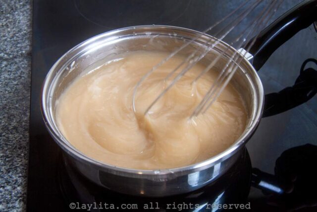 Whisking the coconut mixture in a saucepan after cornstarch was added.