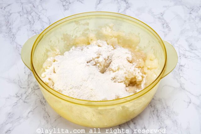 A mixing bowl with mashed yuca, flour, sugar, salt