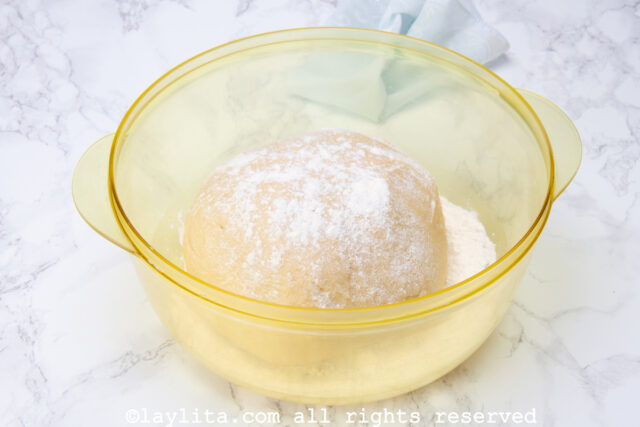Ball of dough in a bowl with four sprinkled on top.