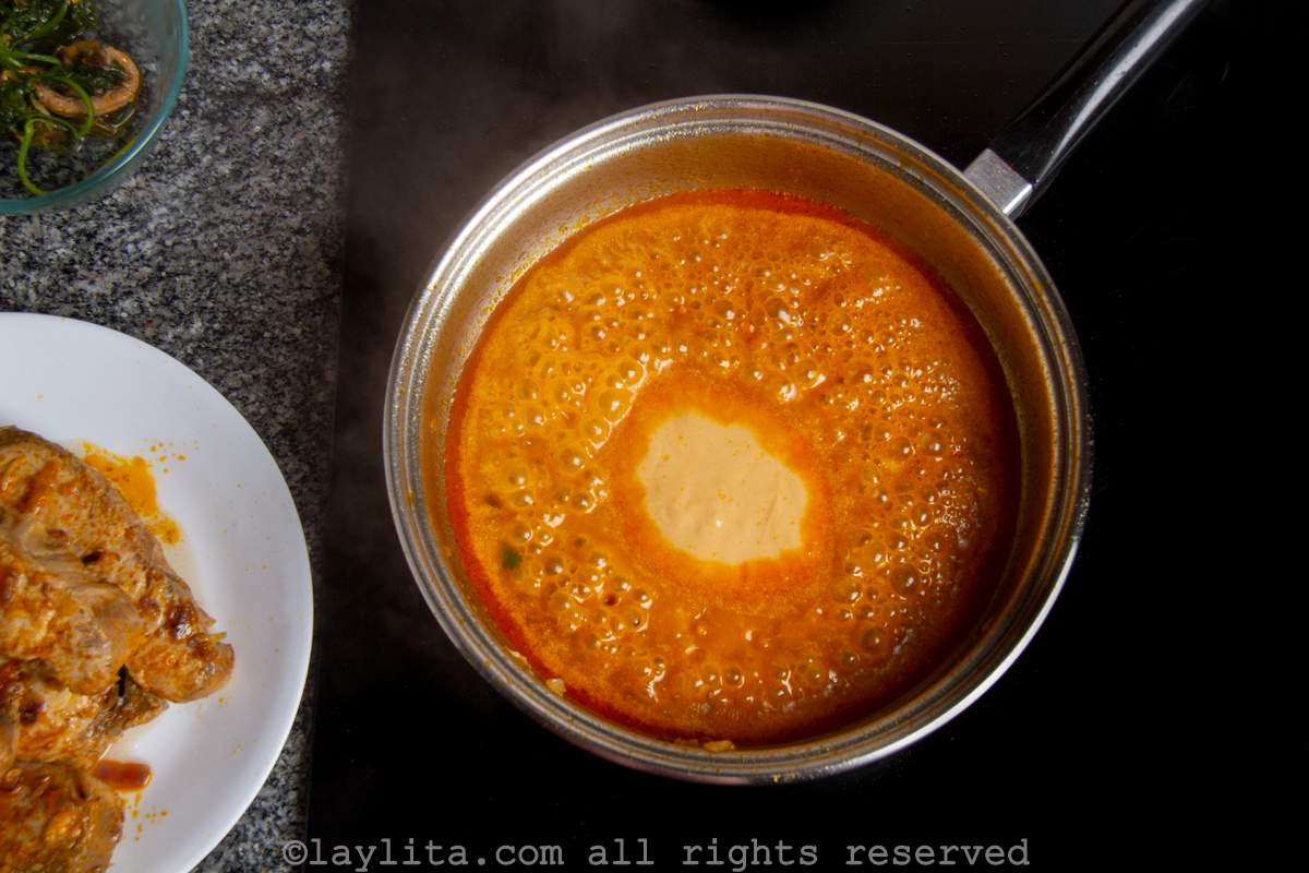 Peanut sauce simmering in a saucepan.