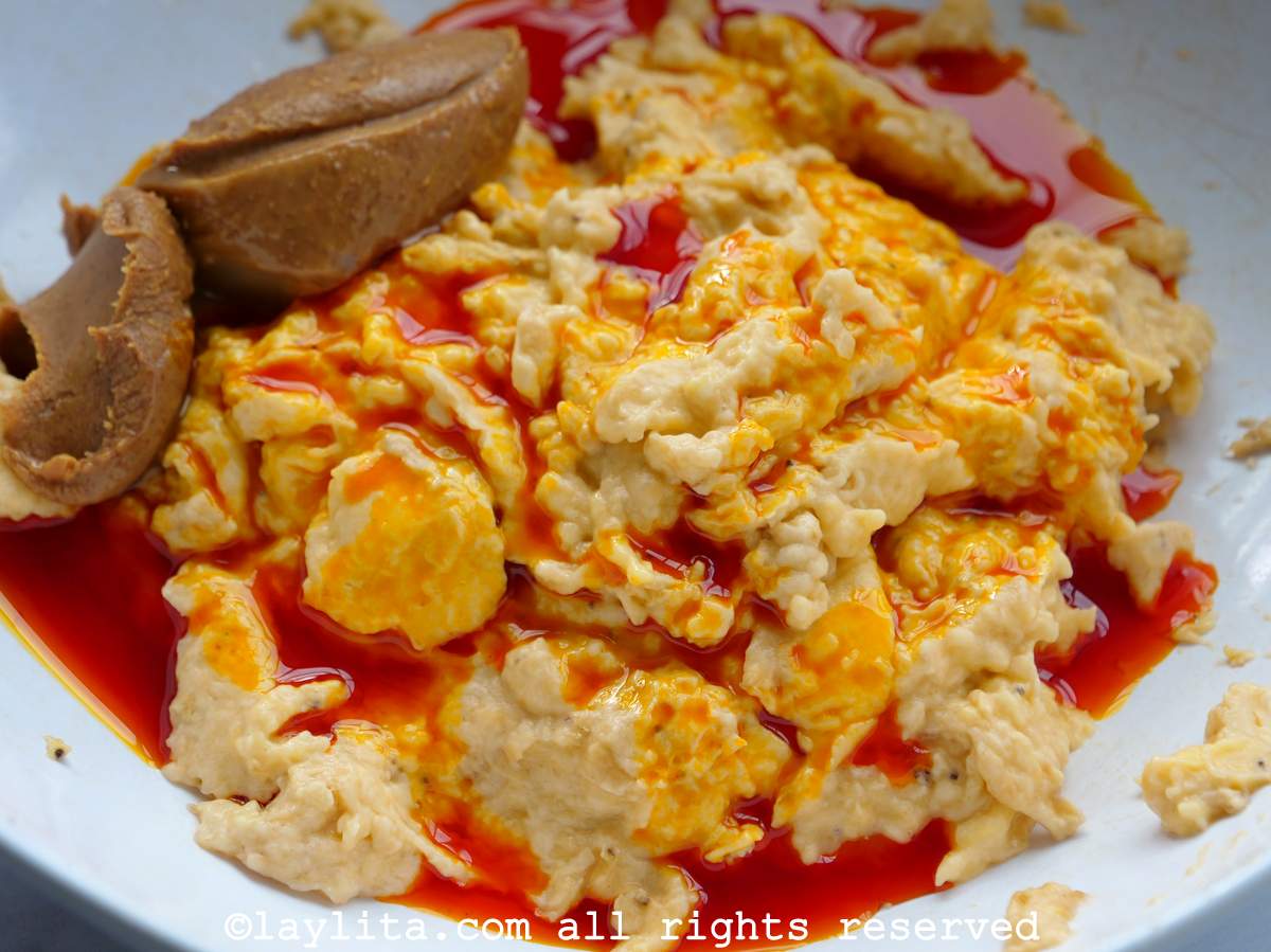 Grated plantains with achiote oil and peanut butter in a bowl.