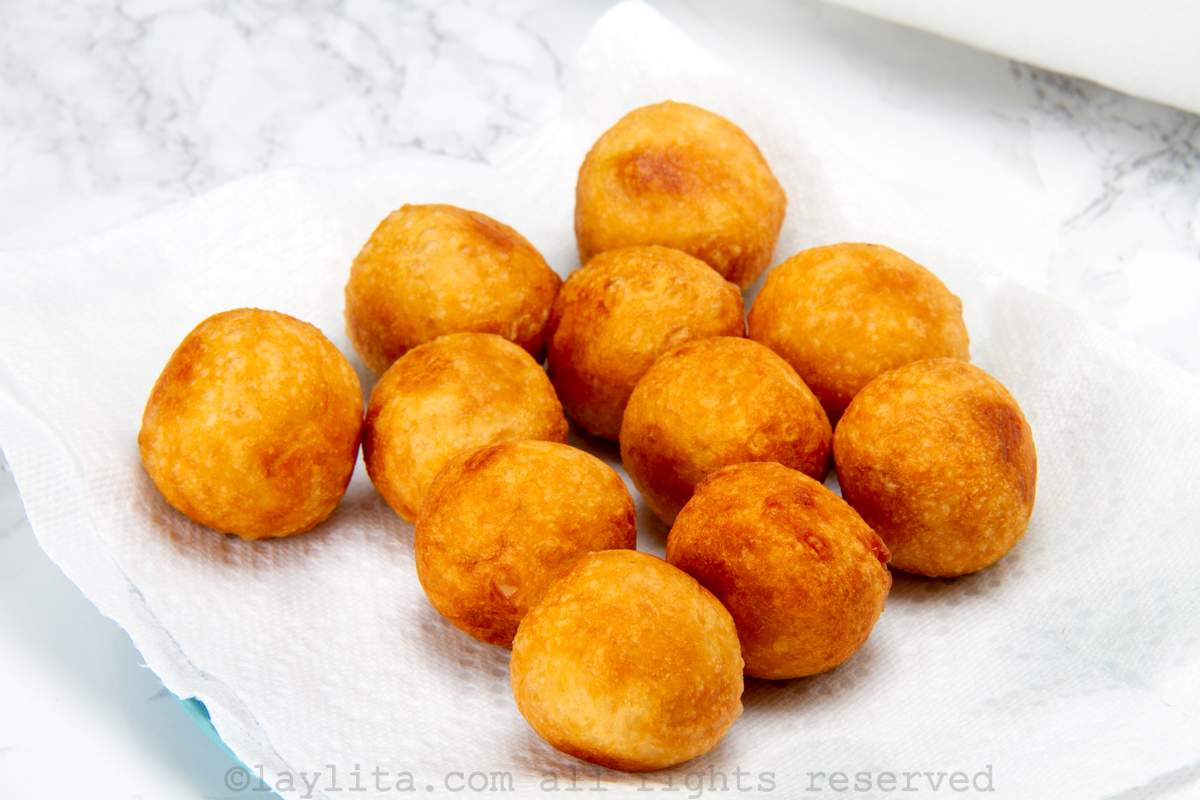 Yuca fritters placed on a paper towel lined plate.