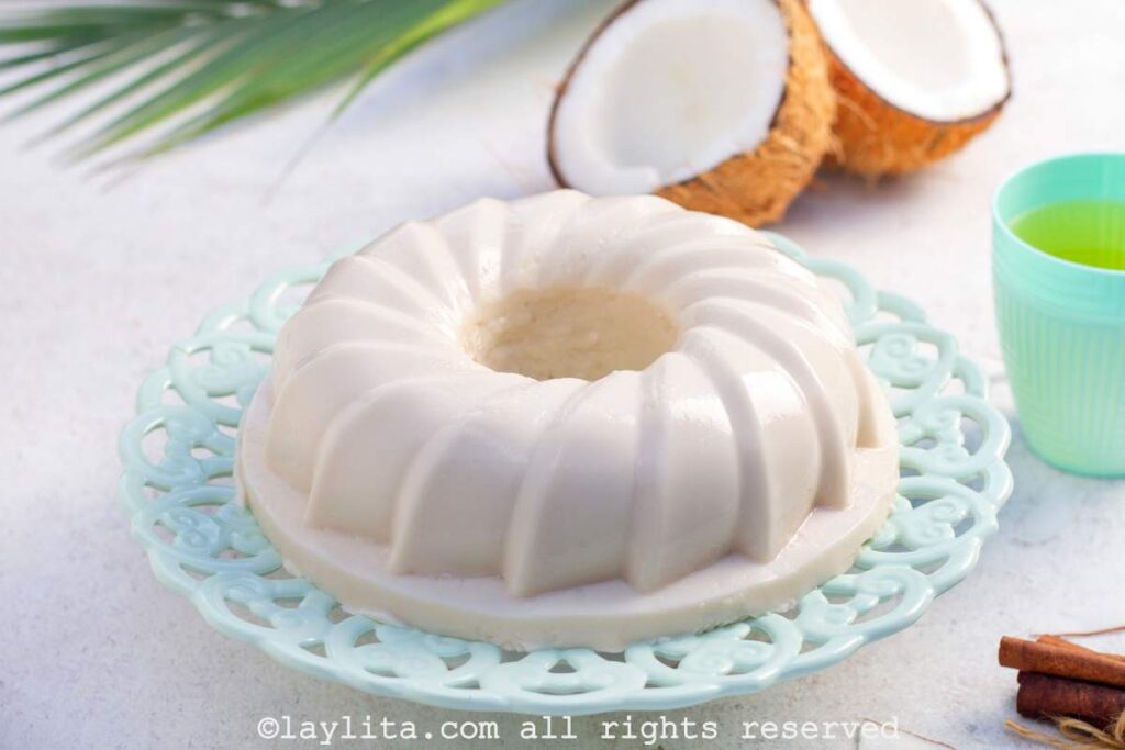 Unmolded Puerto Rican tembleque dessert on a light blue cake stand