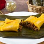 Venezuelan Hallacas or tamales on a banana leaf on top of a white plate