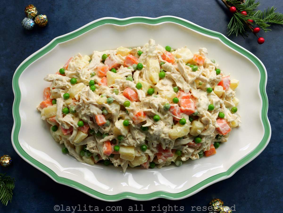 Venezuelan ensalada de gallina served on a white and green serving platter with Christmas decorations around it