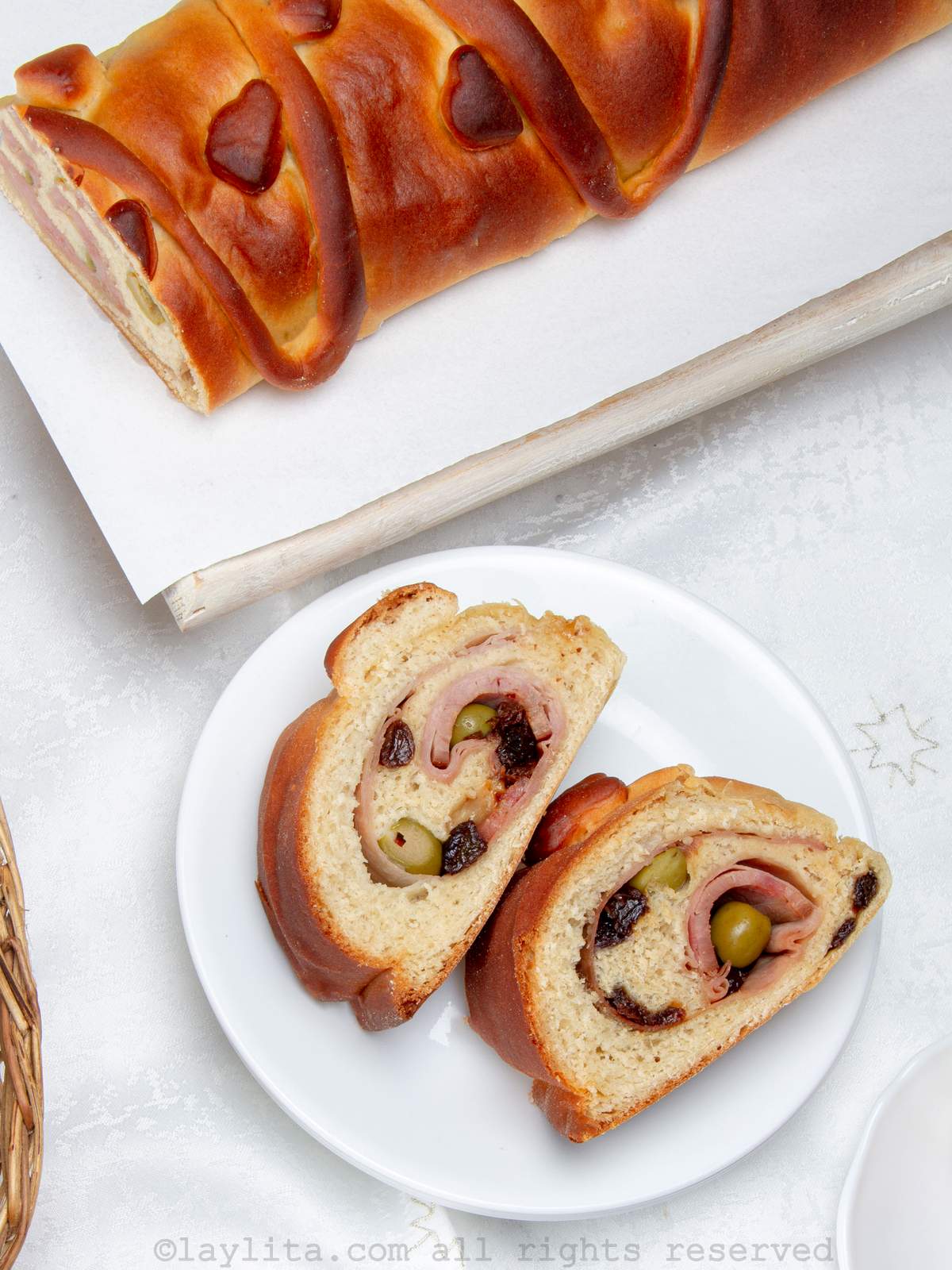 Overhead shot of Venezuelan Christmas bread on a plate with more in a basket next to the plate.