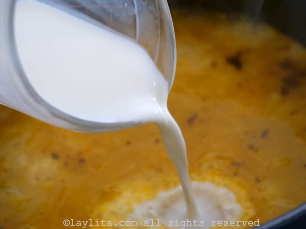 Milk being poured into the simmering soup.