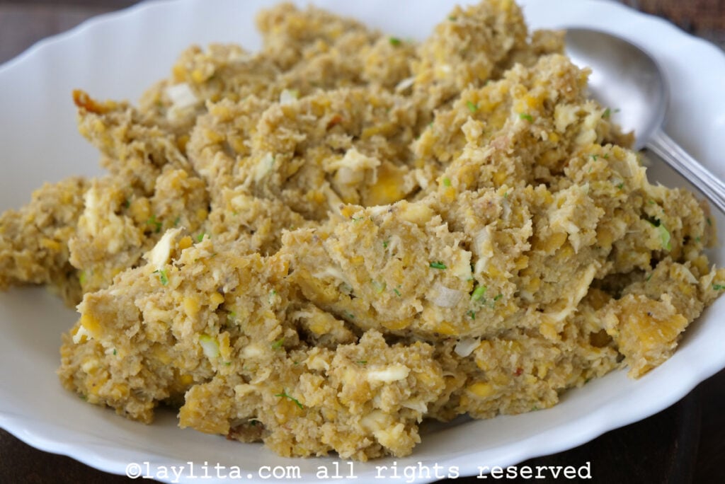 Ecuadorian green plantain mash with cheese or tigrillo con queso in a white serving platter with a spoon