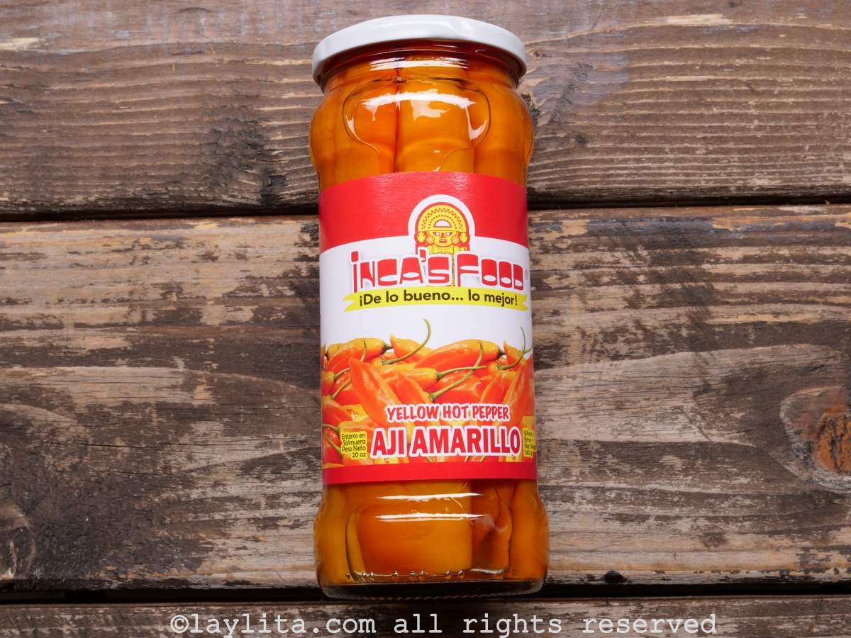 Peruvian aji amarillo or yellow peppers in a jar on a wood table