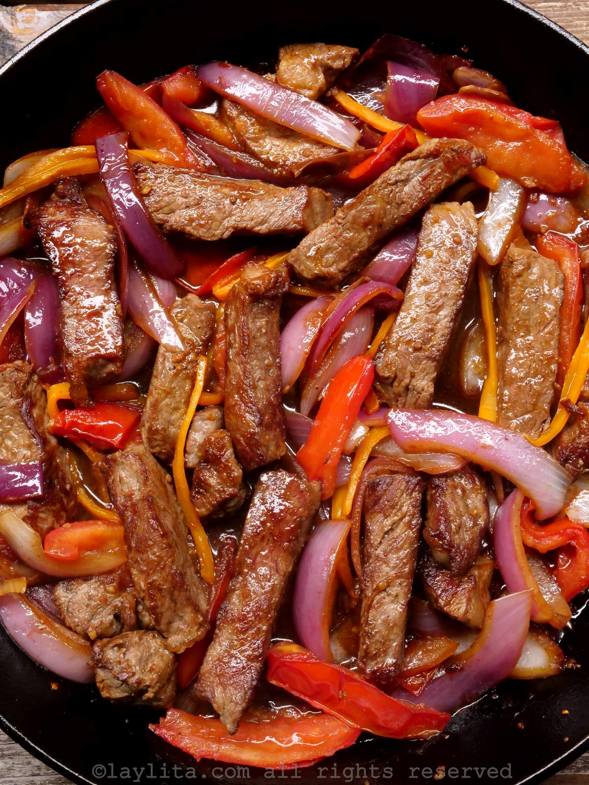 Overhead shot of lomo saltado in a cast iron dish after being mixed together.