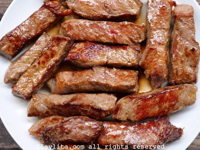 Slices of seared beef on a white plate