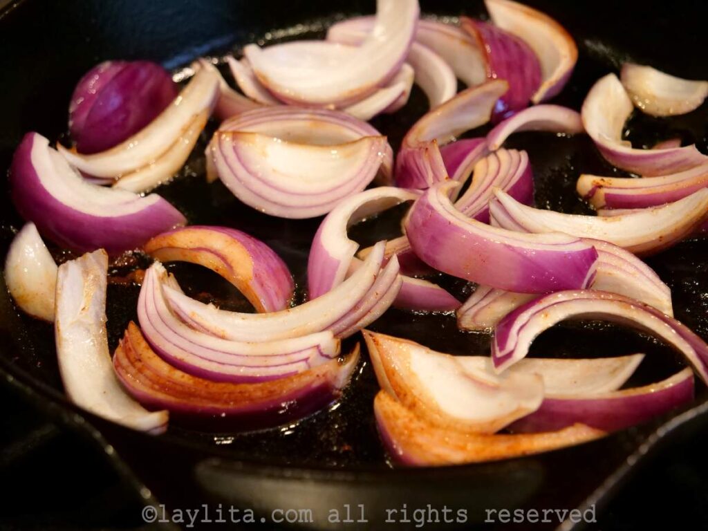 Large pieces of red onion added to the same pan