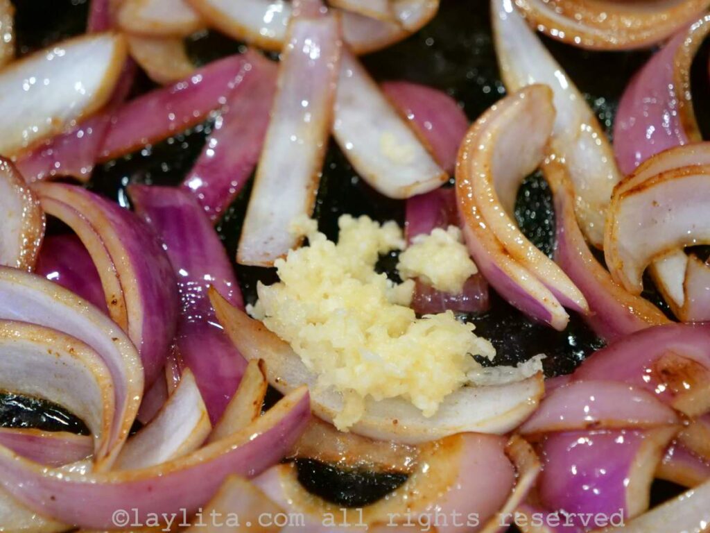 Crushed garlic added to the onions in the cast iron pan.