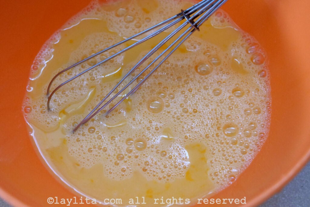 Whisked eggs in an orange bowl