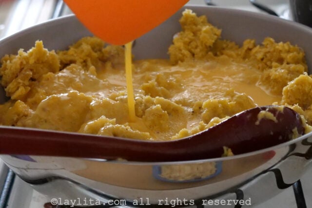 Whisked eggs being added into the plantain mixture in the pan