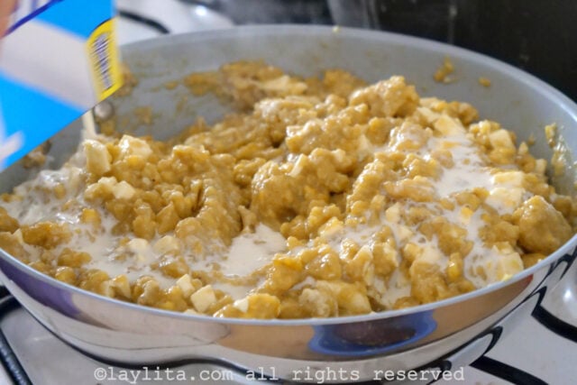 Milk being added to the plantain mixture in a pan