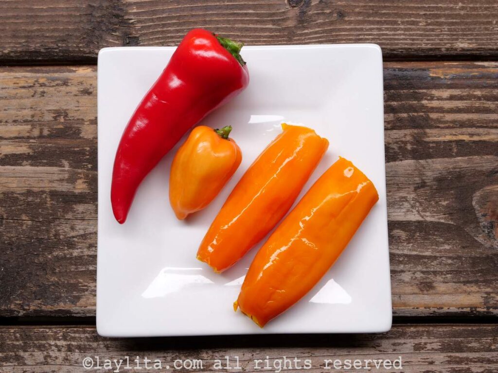 Red fresno chili, habanero pepper and aji amarillo peppers on a white square plate