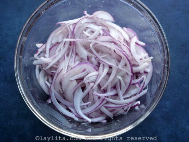 Thinly sliced red onion in a small bowl.