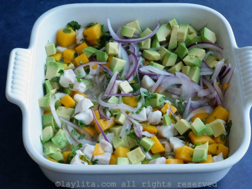 Ceviche with the diced avocado added in a white dish.