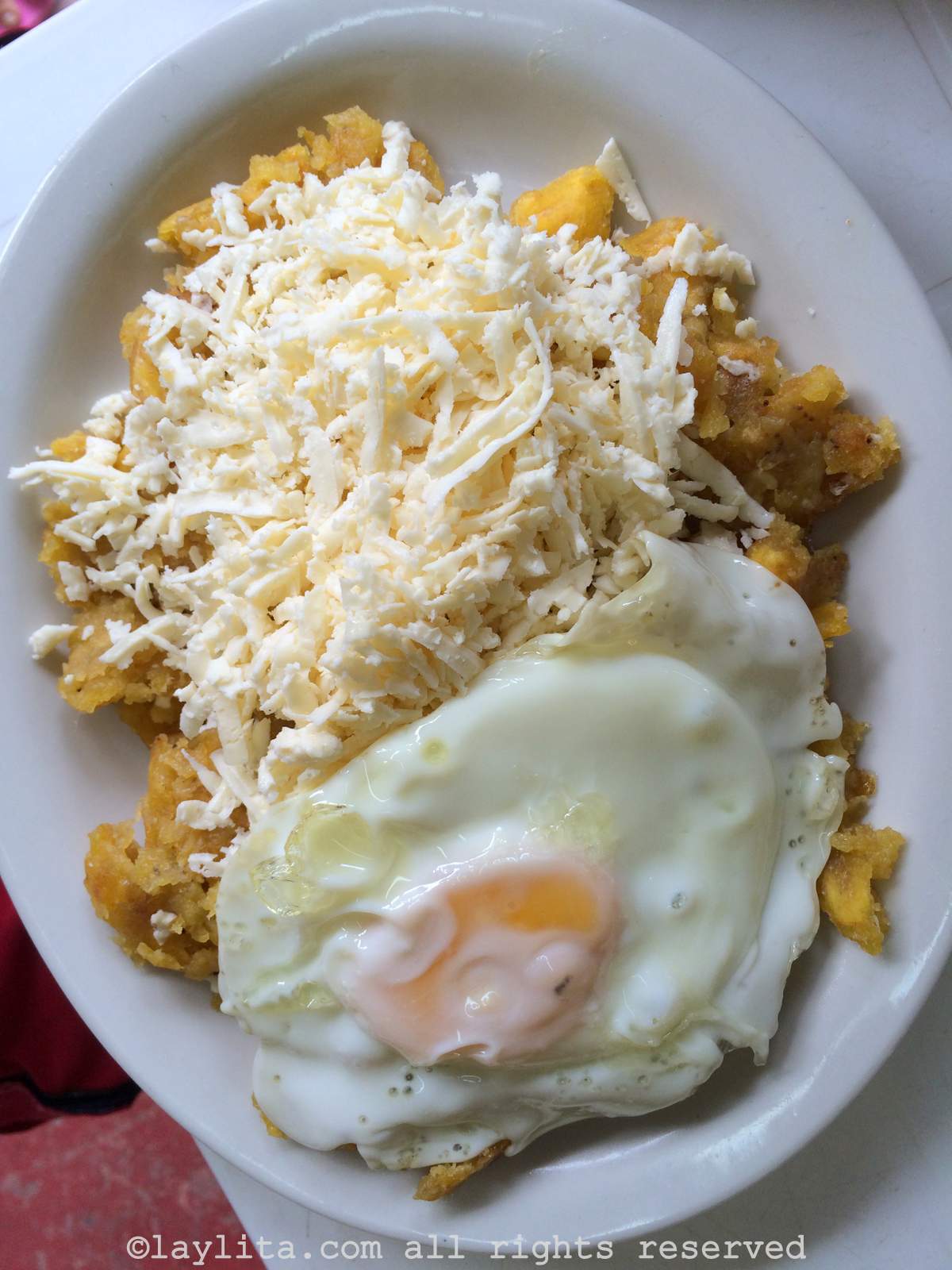 Ecuadorian tigrillo served with grated cheese and a fried egg on top
