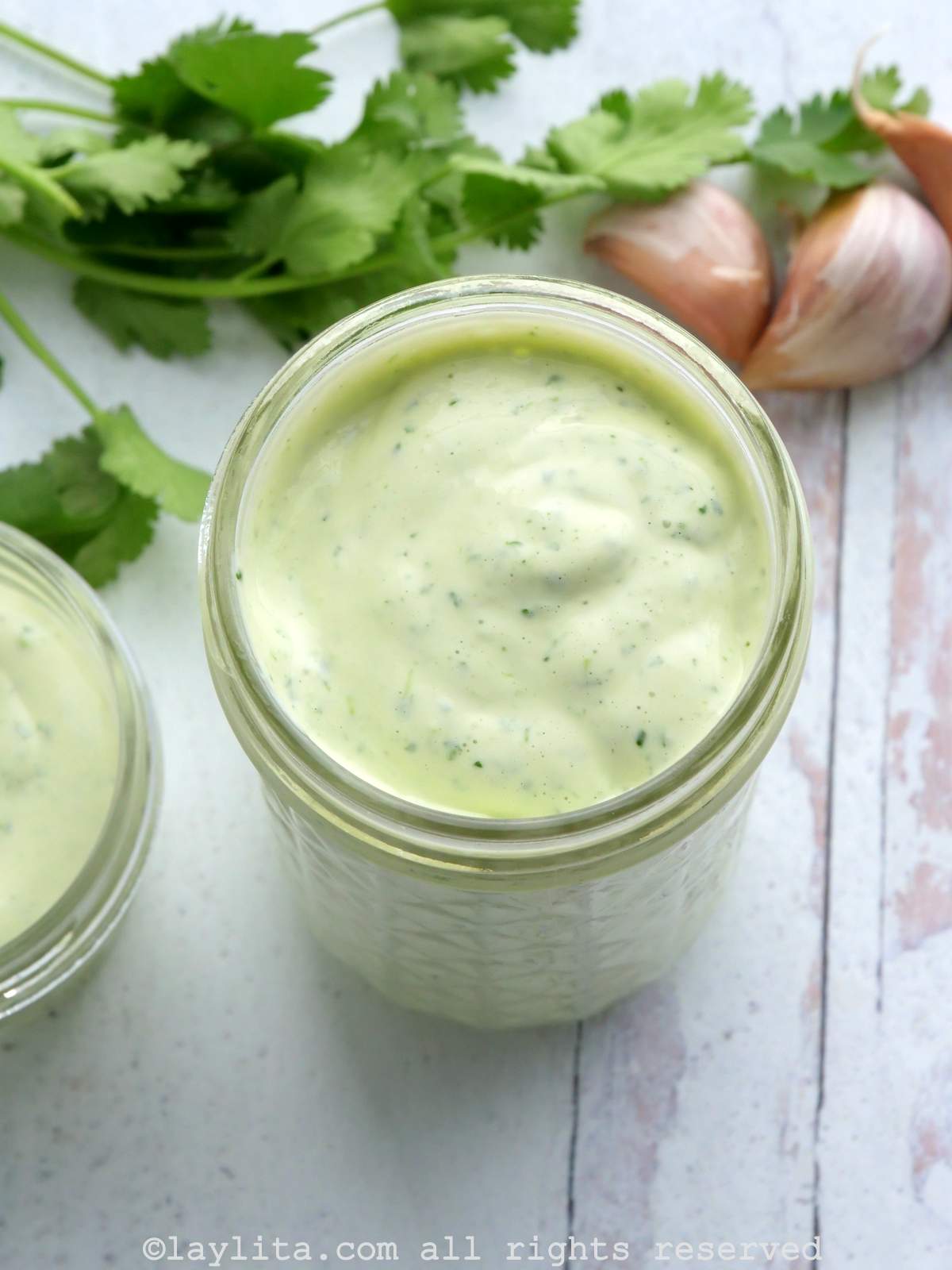 Overhead shot of a jar of green aioli sauce.