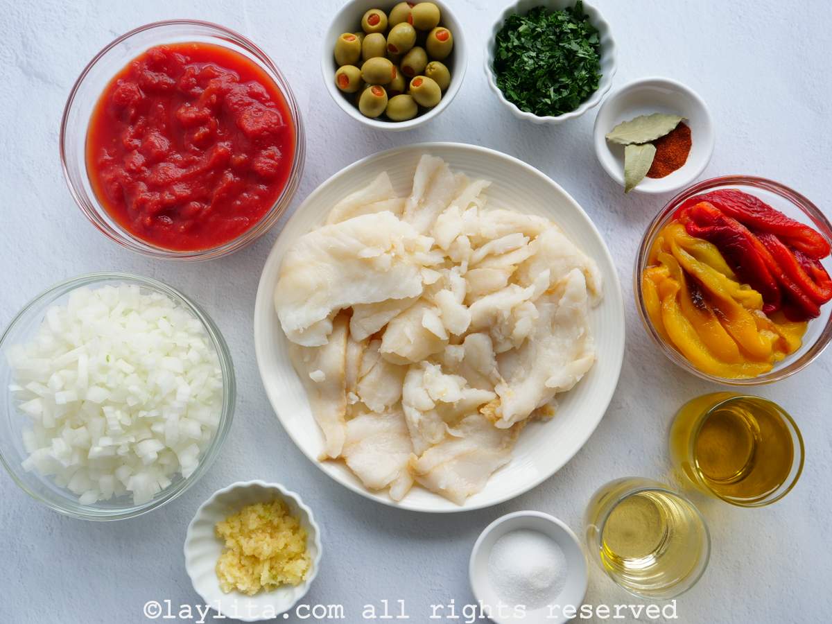 Overhead shot of the ingredients needed to make salted cod fish in a tomato and roasted pepper sauce or bacalao a la vizcaína