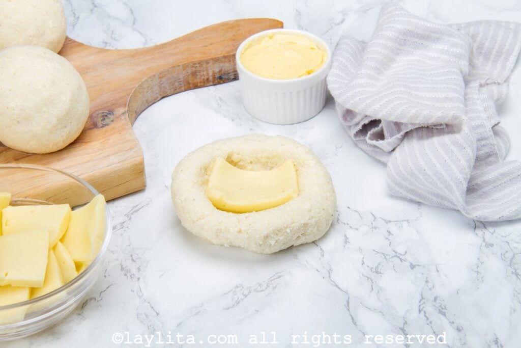 Filling the corn flour arepa patties with cheese