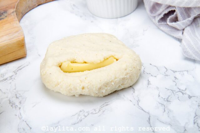 Filling the corn flour arepa patties with cheese