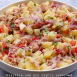 Overhead shot of Ecuadorian tuna potato salad mixed together and served in a shallow white dish.