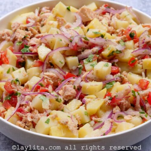 Overhead shot of Ecuadorian tuna potato salad mixed together and served in a shallow white dish.