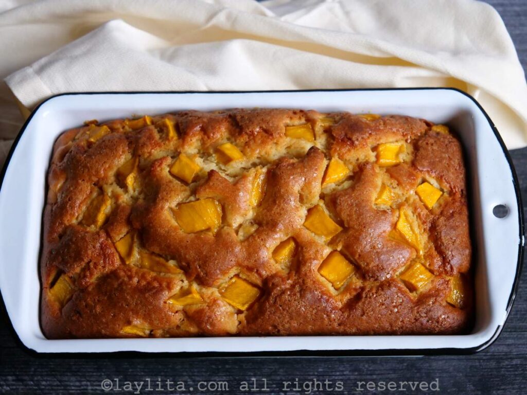 Overhead shot of a mango loaf cake in the loaf pan after being baked.