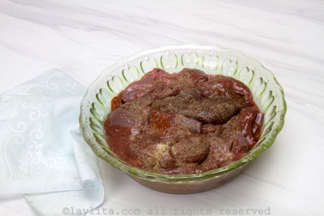 Marinating the thin beef liver steaks with salt, pepper and cumin