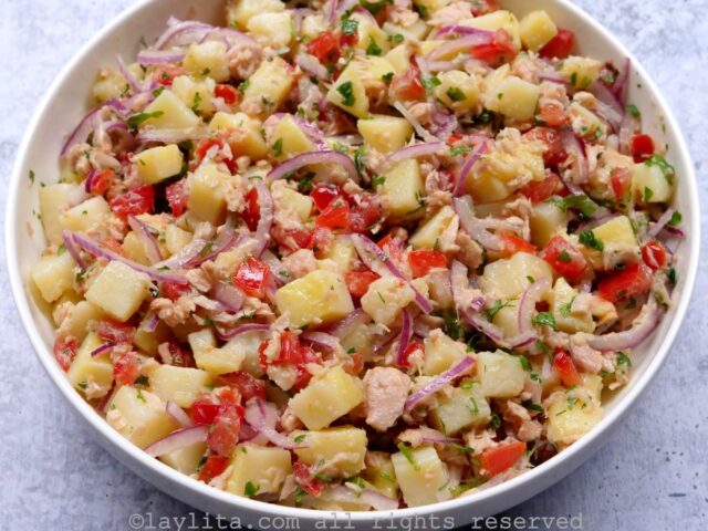 Overhead shot of Ecuadorian tuna potato salad mixed together and served in a shallow white dish.