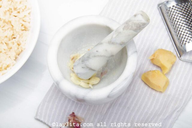 Garlic cloves being crushed in a mortar