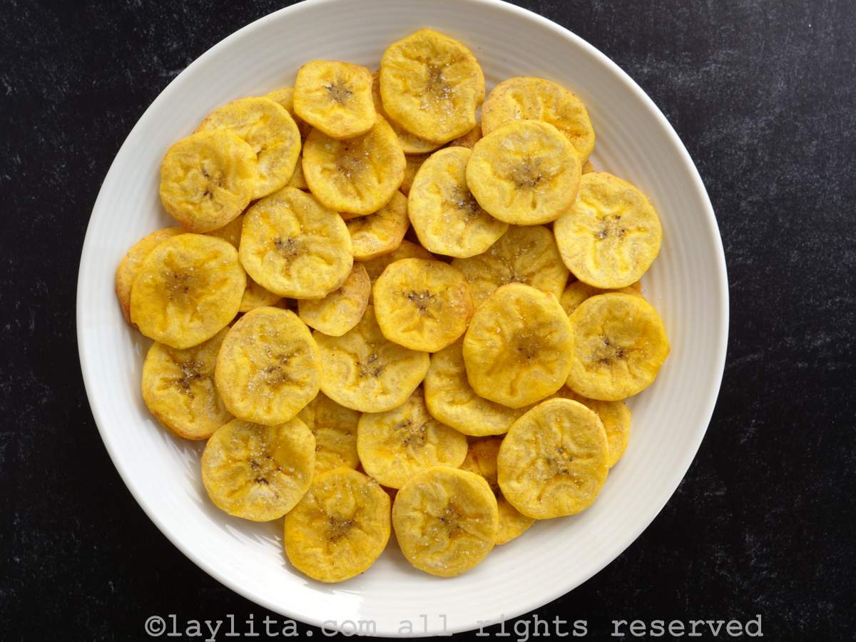Air fryer chifles on a white plate with a black background