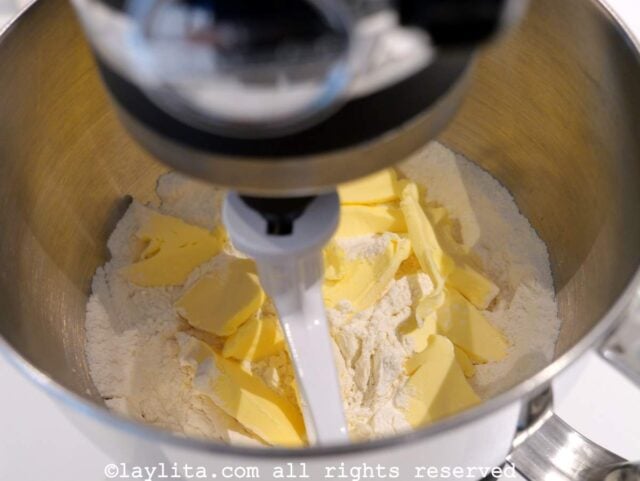 Butter being added to the flour mixture in a mixing bowl