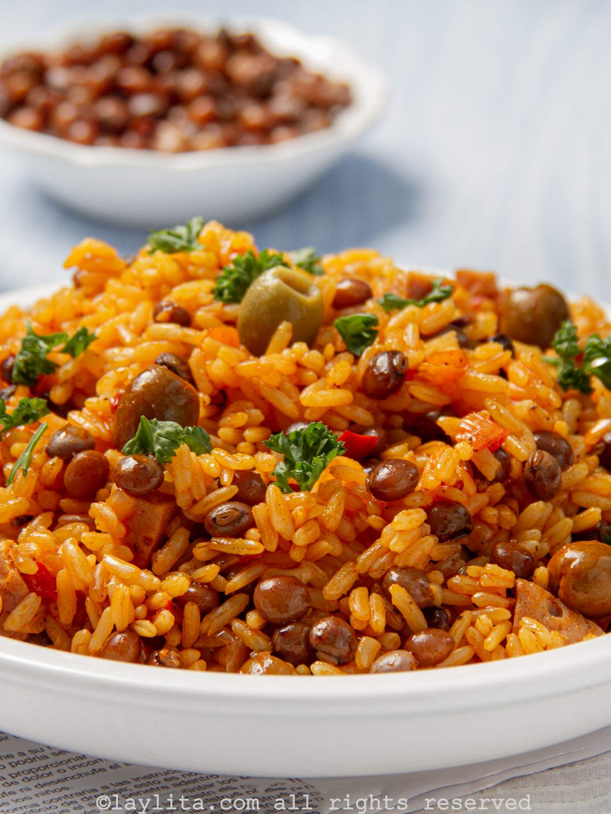 Close up of rice with pigeon peas or arroz con gandules piled high in a bowl. 