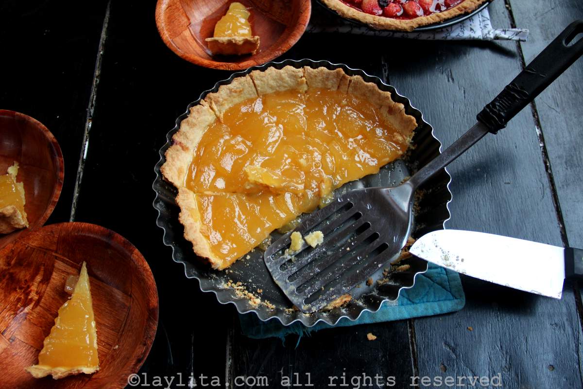 Overhead shot of a babaco tart in the tart pan with bowls of slices on the side