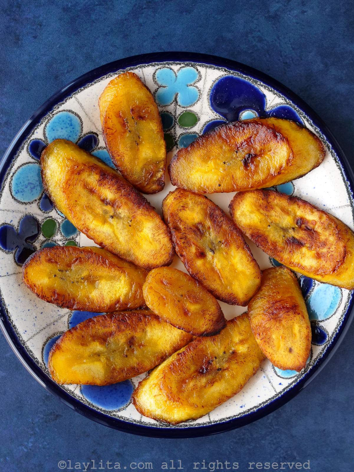 Fried ripe plantains or maduros fritos on floral blue plate